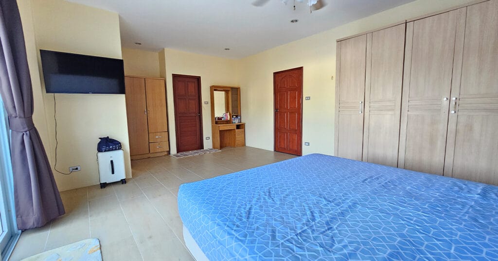 Modern master ensuite bathroom with walk-in shower, tiled walls, vanity unit, and natural light in a Phuket villa.