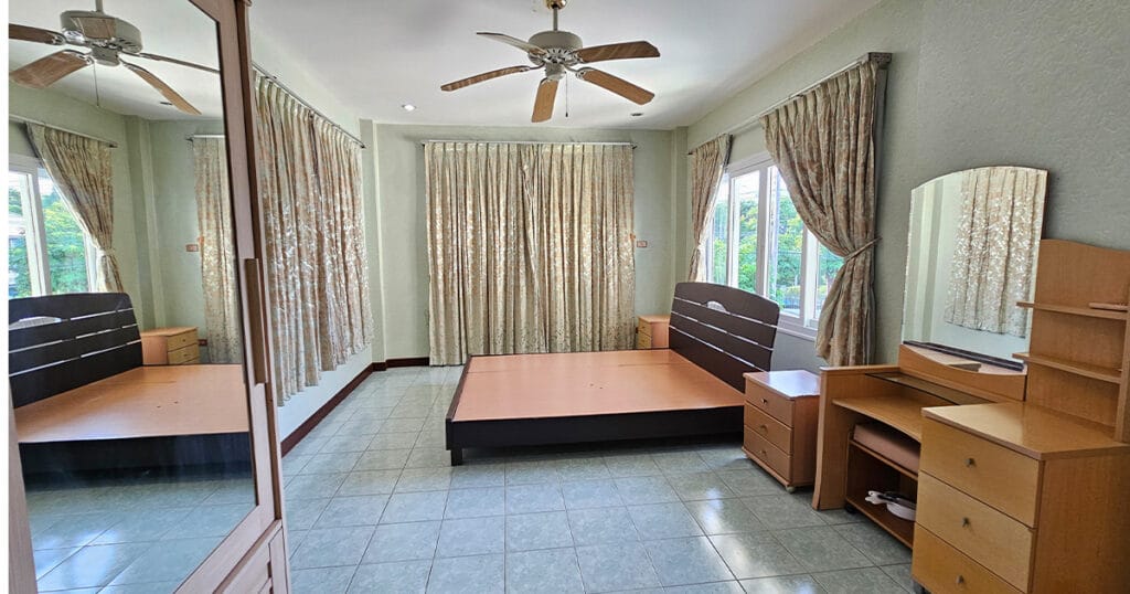 Spacious second bedroom with tiled floors, air conditioning, ceiling fan, and natural light in a Phuket pool villa.
