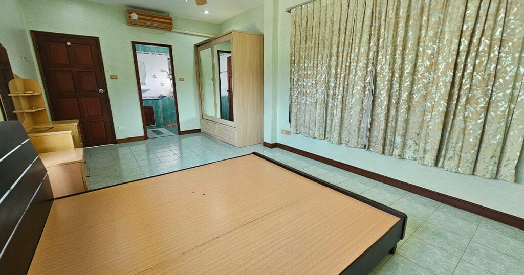 Second bedroom with fitted wardrobe, tiled flooring, and neutral finishes in a well-maintained Phuket villa.
