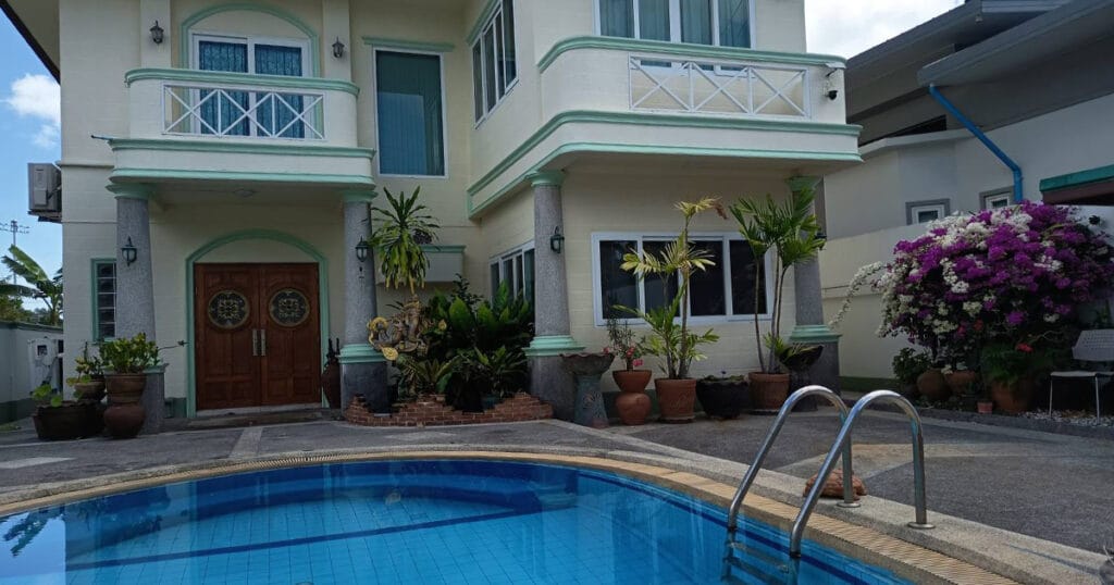 Swimming pool with two-storey villa exterior at Phuket Pool Villa