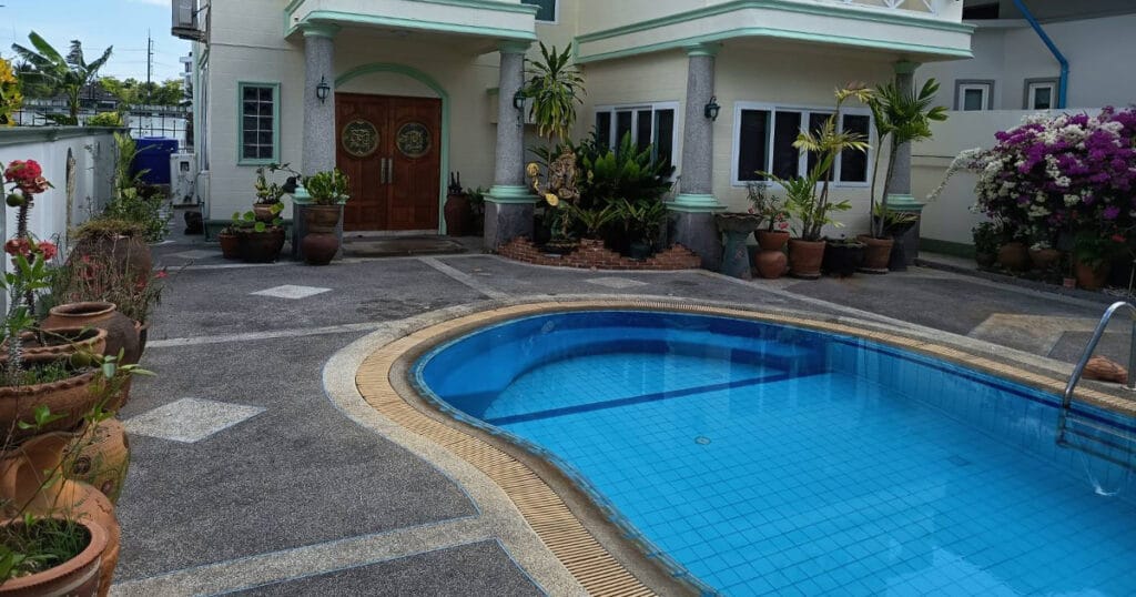 Swimming pool with villa entrance and balcony at Phuket Pool Villa